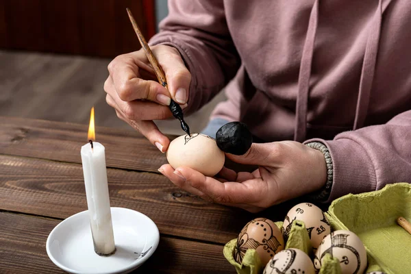Dişi eller geleneksel olarak yumurtaları çiçek desenleriyle boyarlar. Ahşap masada paskalya için dolmakalem ve balmumu kullanırlar. Paskalya hazırlama konsepti.