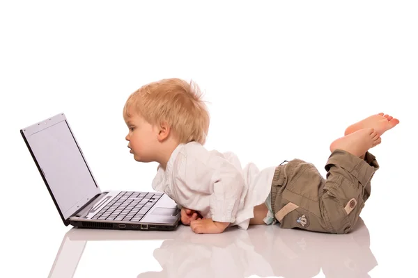 Jongen op zoek naar een laptop — Stockfoto