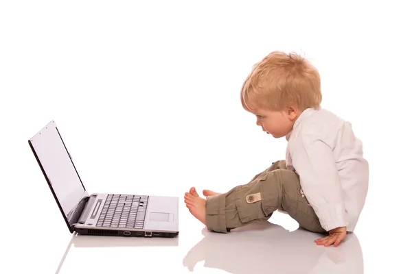 Un băiat se uită la un laptop — Fotografie, imagine de stoc