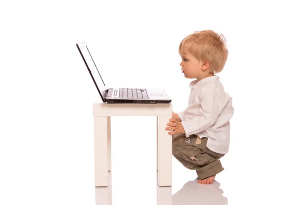 Jongen op zoek naar een laptop — Stockfoto