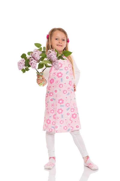 Smiling little girl with lilac flowers — Stock Photo, Image