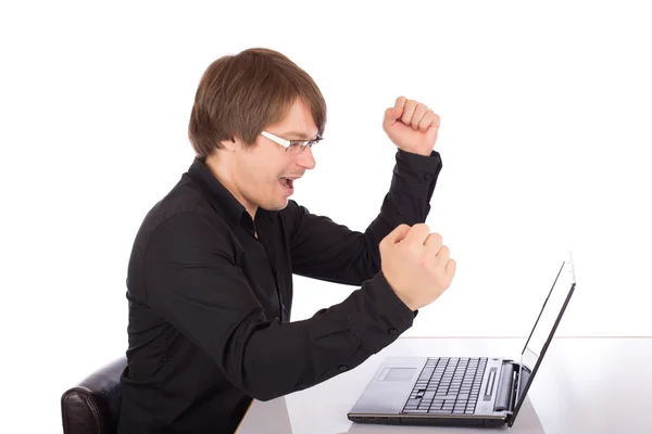 Homem de negócios levanta os braços na frente de seu laptop — Fotografia de Stock