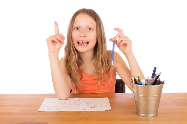 Child sitting at a table found an idea to draw Stock Image