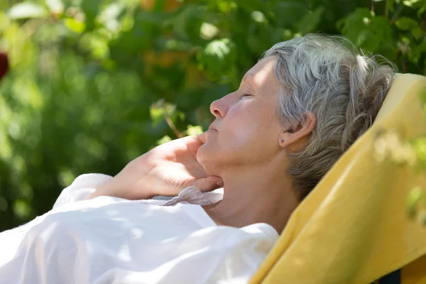 ラウンジャーで寝ている高齢者の女性 — ストック写真