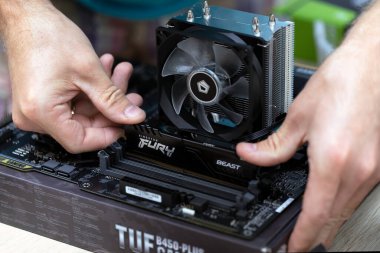 Close up of electronic engineer installing Fury Beast RAM DDR4 stick on motherboard of professional computer for cryptocurrency mining. Russia, 17.08.2021