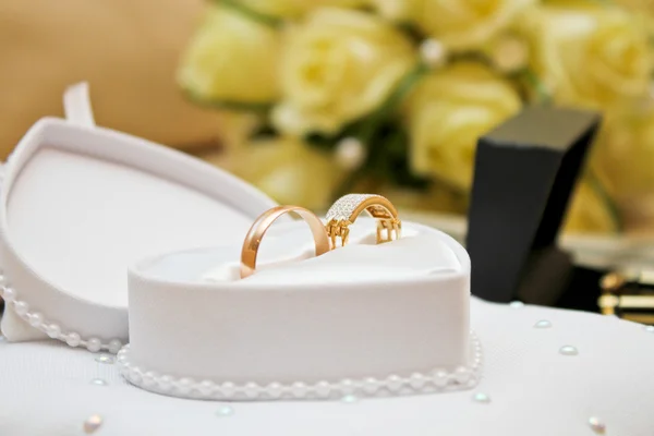 Snubní prsteny v krabici na pozadí kytice — Stock fotografie
