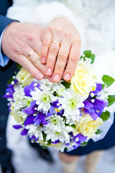 Hände und Ringe am Brautstrauß — Stockfoto
