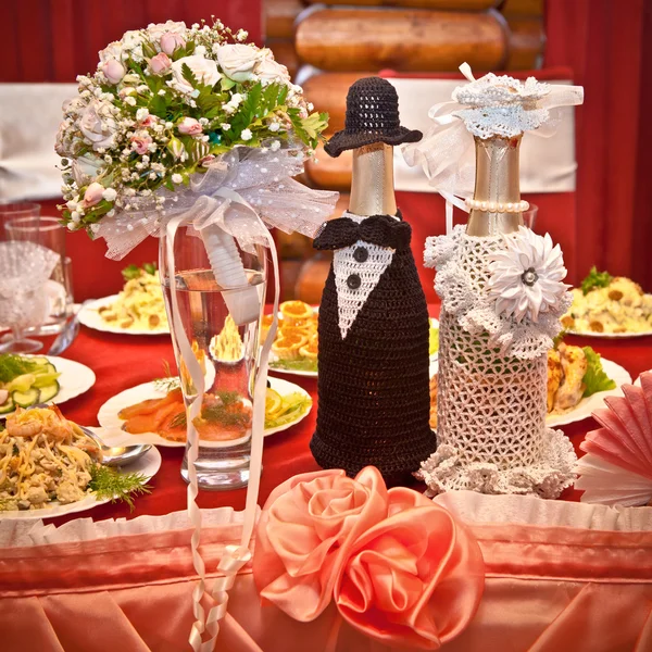 Champanhe de casamento e um buquê em uma mesa decorada — Fotografia de Stock