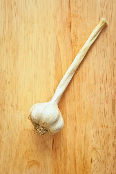 Cabeza de ajo sobre una tabla de madera — Foto de Stock