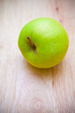 Ahşap arka planda yeşil elma