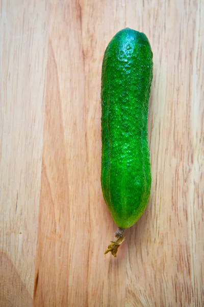 Pepino verde em um fundo de madeira — Fotografia de Stock