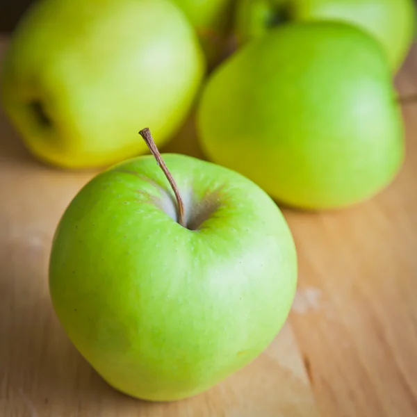 Green apples on a wooden board — Stock Photo, Image