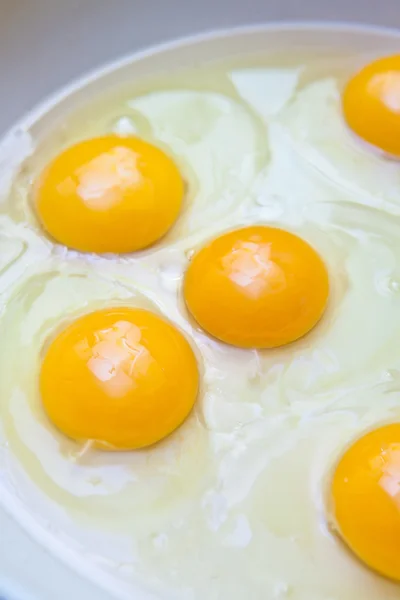 Сырой белок и яичный желток в сковороде — стоковое фото