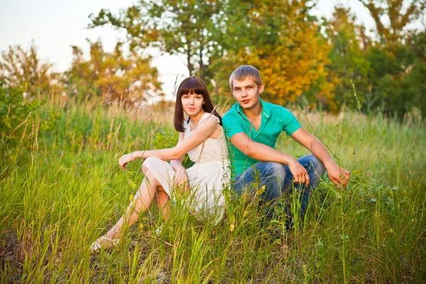 Portrait of young romantic couple sitting in forest enjoying — Stock Photo, Image