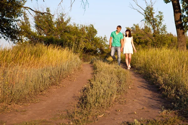 Feliz joven pareja caminando por un sendero en el bosque —  Fotos de Stock