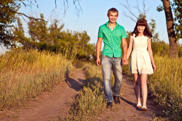 Jovem casal feliz andando em um caminho na floresta — Fotografia de Stock