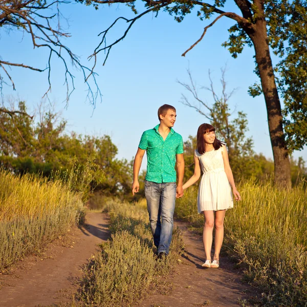 Jovem casal feliz andando em um caminho na floresta — Fotografia de Stock