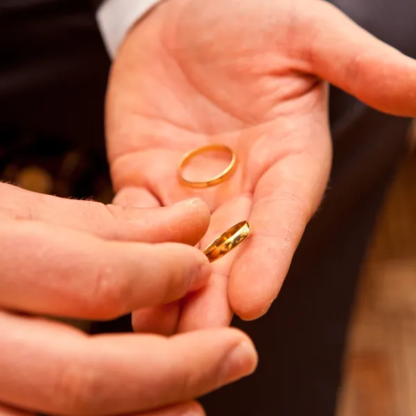 Жених держит обручальное кольцо на руке — стоковое фото