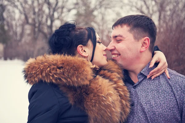 Young couple kissing in the winter forest — Stock Photo, Image