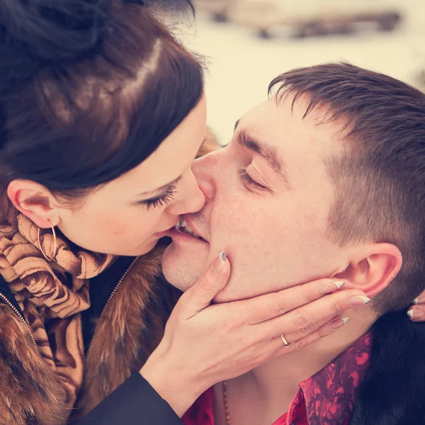 Ungt par kyssas i skogen vinter — Stockfoto