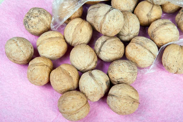 Lots of walnuts on a purple background — Stock Photo, Image