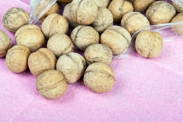 Lots of walnuts on a purple background — Stock Photo, Image