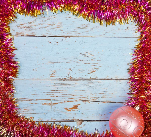 Wooden background in a frame of the Christmas tinsel — Stock Photo, Image
