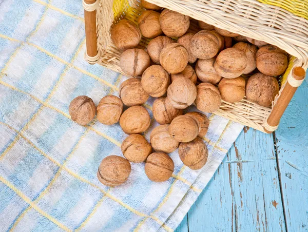 Vlašské ořechy na stole v obrácené proutěný koš — Stock fotografie