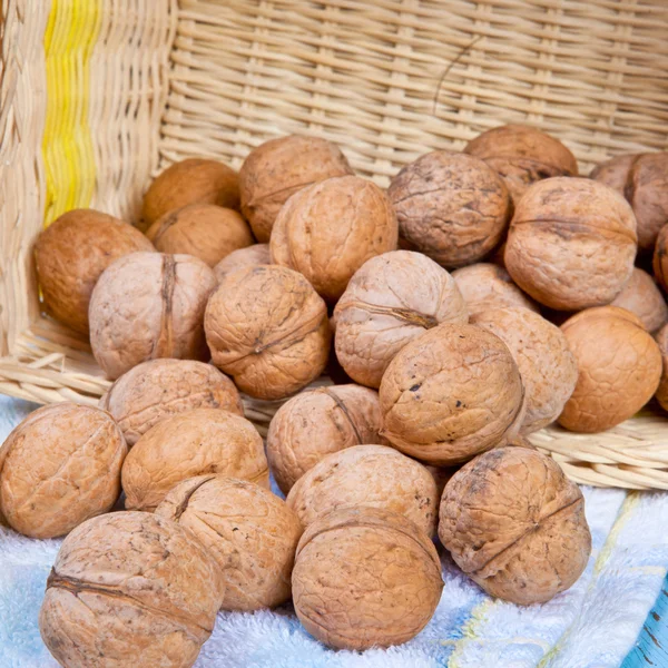 Walnuts on the table in an inverted wicker basket — Stock Photo, Image