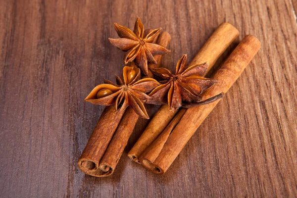 Palitos de canela y anís estrellado sobre un fondo de madera — Foto de Stock