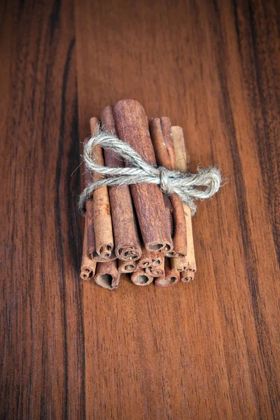 Bâtons de cannelle connexes sur fond en bois — Photo