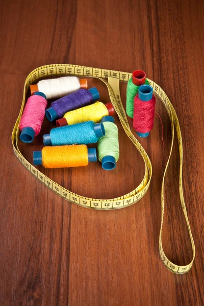 Colorful spools of thread on a wooden background — Stock Photo, Image