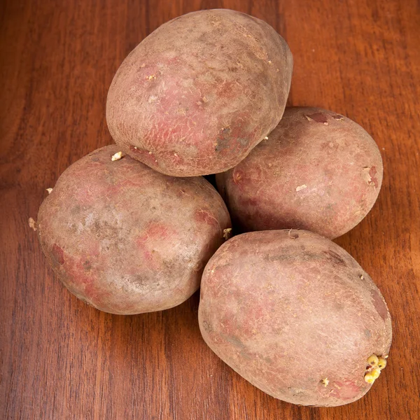 Patatas crudas sobre fondo de madera —  Fotos de Stock