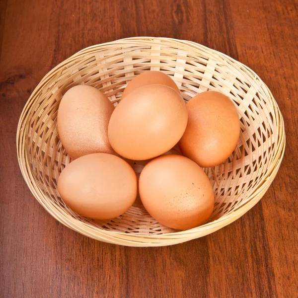 Chicken eggs in a wicker basket on the table — Stock Photo, Image