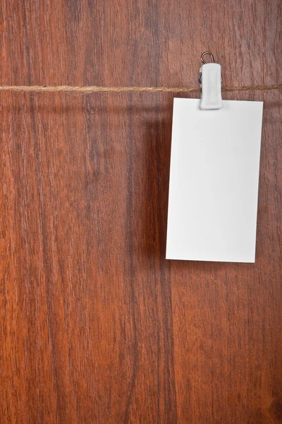 Пустая карточка на веревке на деревянном фоне — стоковое фото