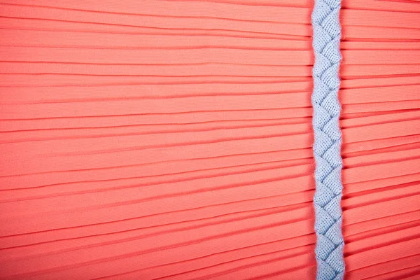 Gewebter Textilgürtel auf rotem Seidenhintergrund — Stockfoto