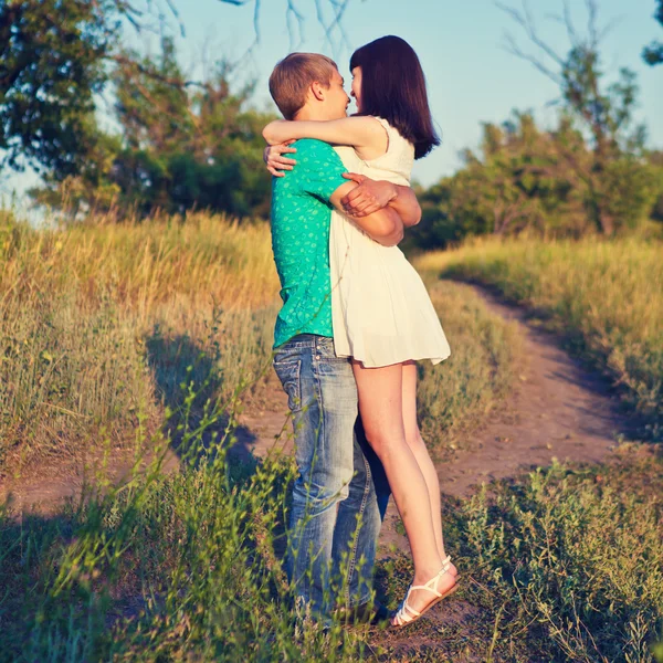 Loving couple embracing on the road in the woods — Stock Photo, Image