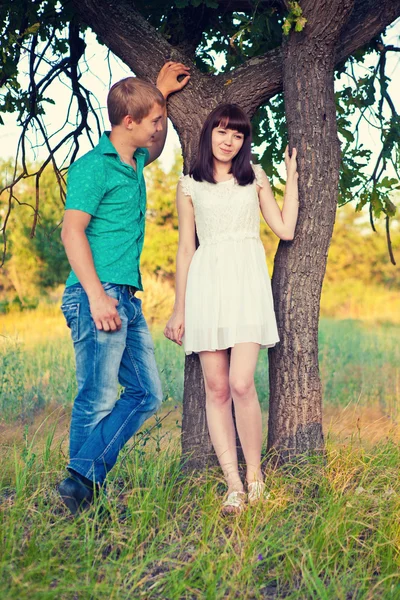 Pareja joven besándose bajo un árbol — Foto de Stock