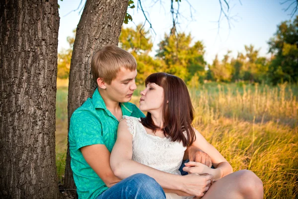 Νεαρό ζευγάρι φιλί κάτω από ένα δέντρο — Φωτογραφία Αρχείου
