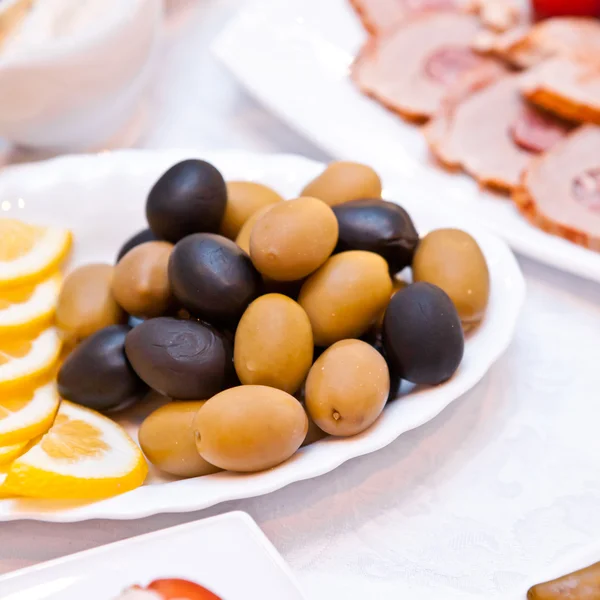 Olive e fette di limone su un piatto — Foto Stock