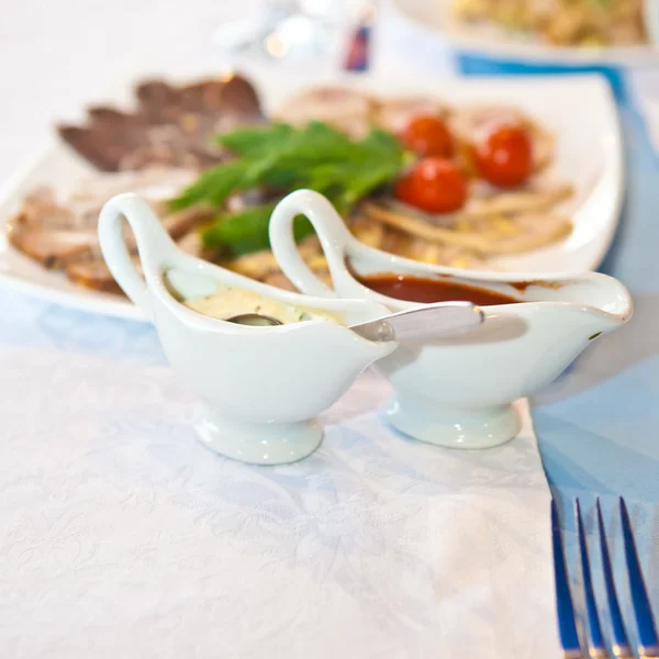 Two ceramic saucers on decorated table — Stock Photo, Image