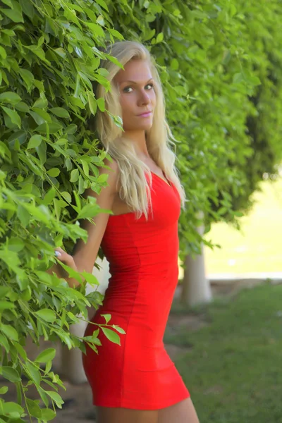 Blonde in a red dress in the park — Stock Photo, Image
