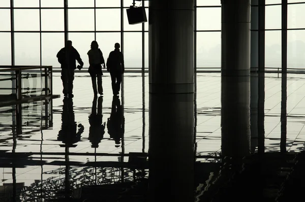 Viaggiatori sagomati in un terminal aeroportuale — Foto Stock