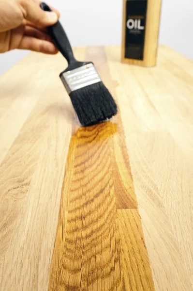 Cepillar aceite sobre una superficie de madera — Foto de Stock
