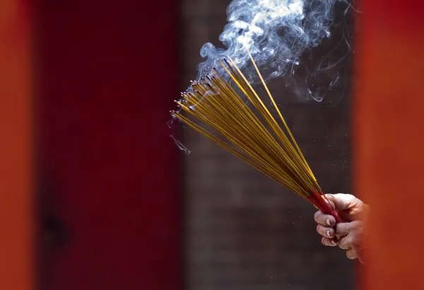 Mãos acenando varas de incenso de fumar no Templo — Fotografia de Stock