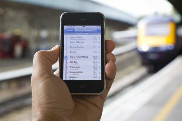 Utvecklingen av ett sent tåg visas på smartphone — Stockfoto