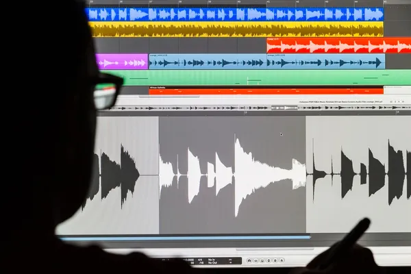 Mann bearbeitet digitales Audio auf einem Computer Stockbild