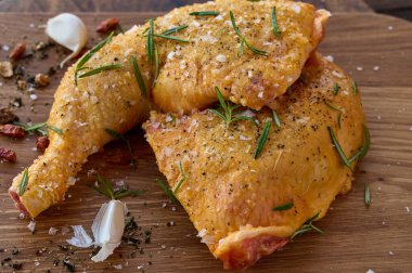 Tuz, sarımsak, karabiber, biberiye ve arnavut biberiyle marine edilmiş çiğ tavuk taytı pişirilmeye hazır.