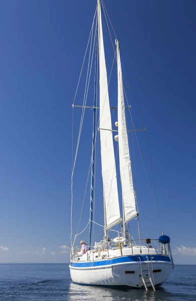 Um casal sénior feliz sentado na frente ou arco de um barco à vela — Fotografia de Stock