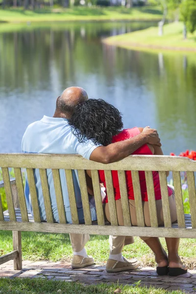 Tre unga kvinnor insvept i amerikanska flaggor på en strand — Stockfoto